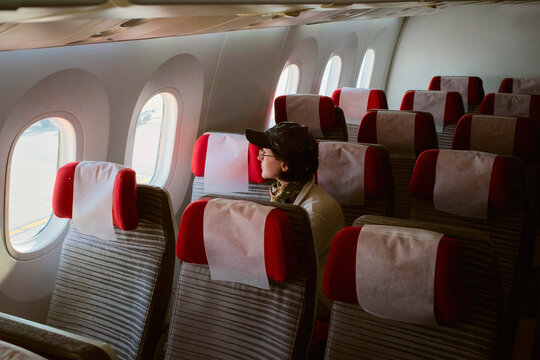 Passenger Looking out Window on Airplane During Flight