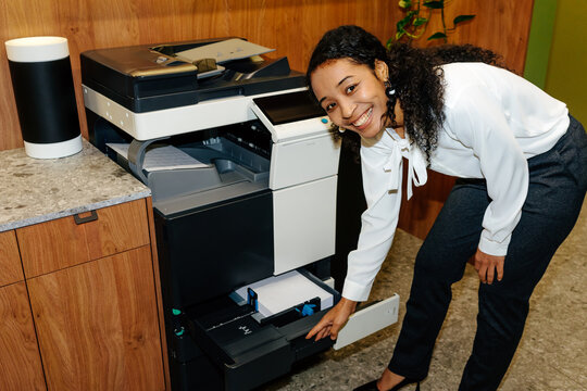 Office Employee Loading Paper into Printer in Workplace