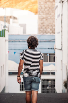 Young man walking through a narrow European street
