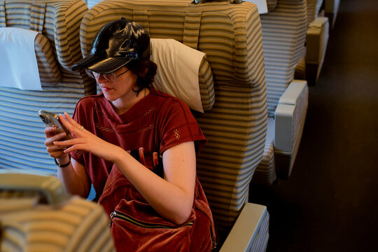 Woman Checking Her Phone on a Train During a Travel Journey