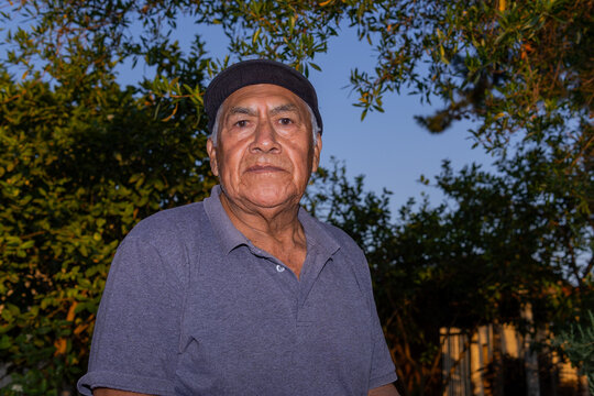 Elderly latino farm worker outdoors under evening light