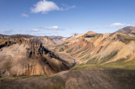 Hiker in red jacket at canyon edge, Landmannalaugar Iceland