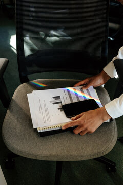 Smartphone and Documents on Office Chair with Rainbow Light Reflection