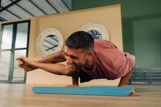 Man Practices Yoga With Balance in a Studio During Daytime