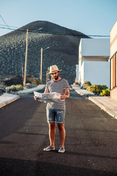 Traveler man navigating with map on an unpaved road