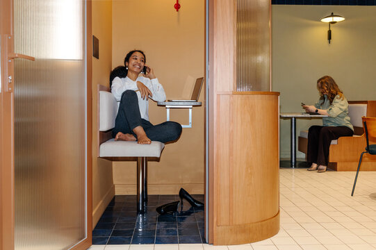 Businesswoman Talking on Phone in Office Privacy Booth