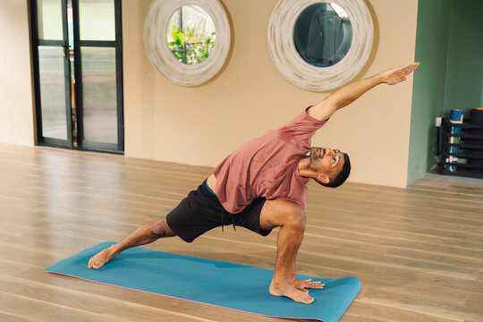 Man Practicing Yoga in a Modern Studio During the Day