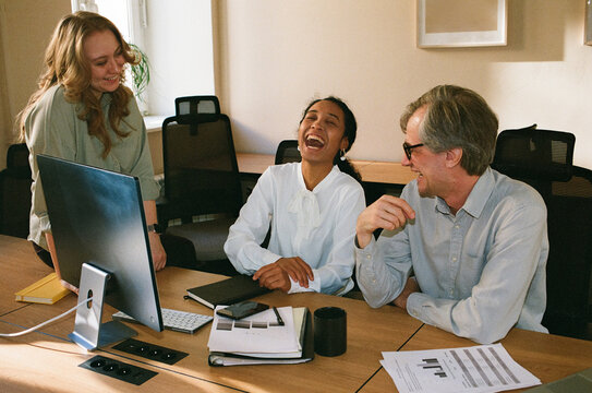 Business Colleagues Smiling During Friendly Office Team Meeting