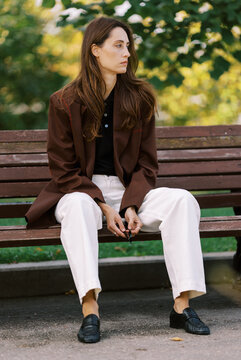 Woman Sitting on a Bench in a Park During Daytime