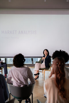 Woman presents market analysis to audience.
