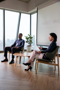 Business professionals discuss market analysis and strategic planning.