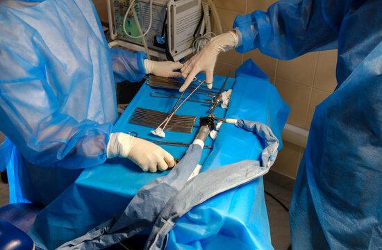 hands of an intern and a doctor near instruments on a table