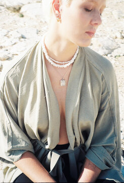 Model Poses in Natural Light Wearing Jewelry and Casual Clothing