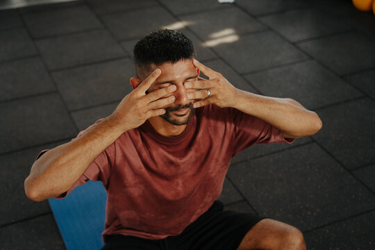 Man Practices Breathing Exercises in a Gym During Morning Hours