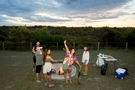 UGC Mixed friends posing by campfire at campsite in Australia 
