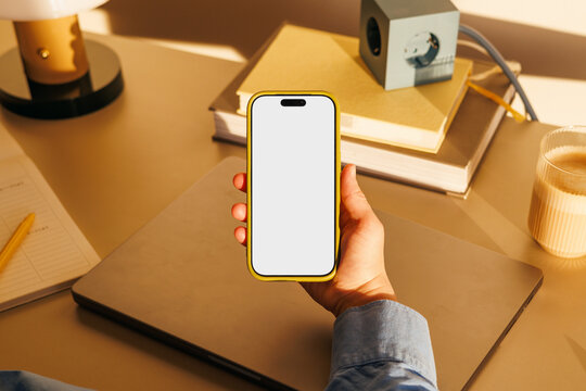 Phone mockup with white screen at office desk