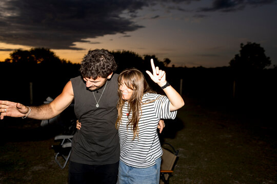 UGC Friends dancing together at campsite in Australia with flash