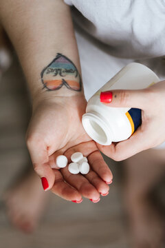 A woman holds a bottle of pills.