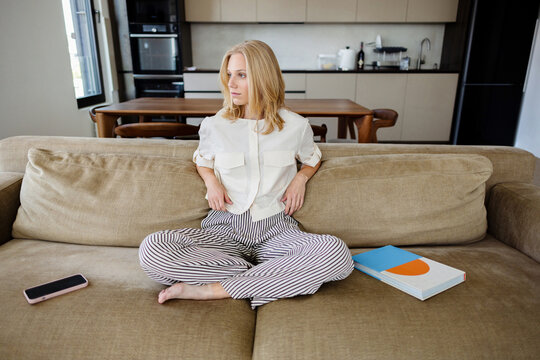 Relaxed Woman Sitting on Sofa in Modern Living Room
