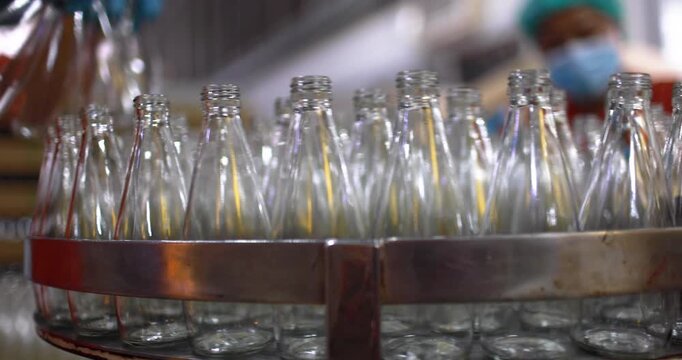 At beverage bottles line, focused workers systematically organizes the bottles into a large container. then staged at the loading dock, ready for distribution in beverage drinking water factory