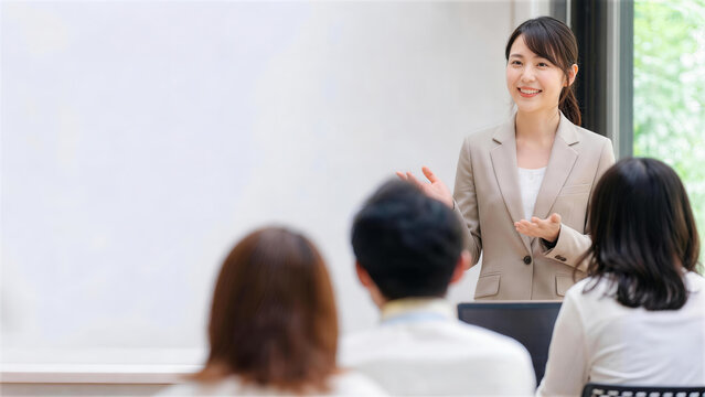 スクリーンの前で聴衆にプレゼンテーションをする笑顔のビジネスウーマン