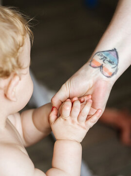 The child holds his mother's hand.