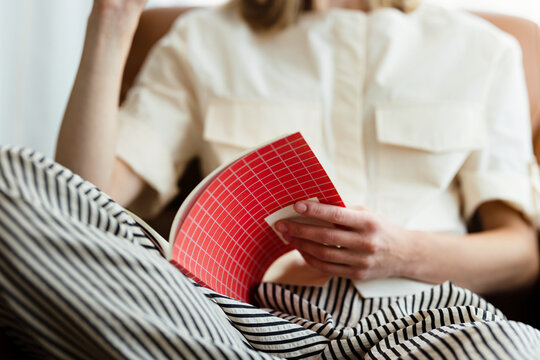 Relaxed Woman Reading From a Red Notebook 
