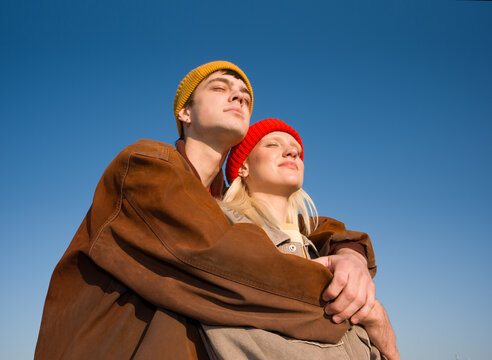 Couple Enjoys Sunny Day With Colorful Hats in Clear Sky