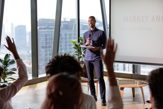 Presenter at market analysis seminar answers audience questions.