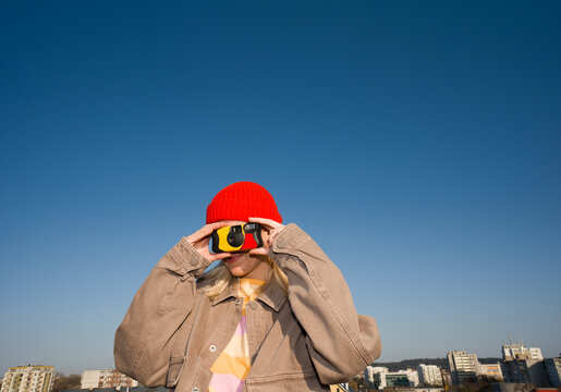 Woman Using Disposable Camera In Blue Sky 