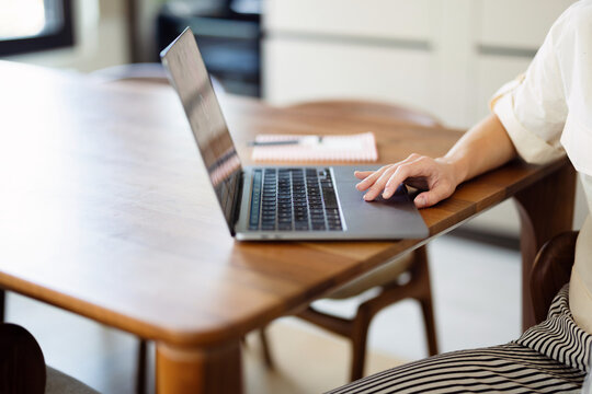 Person Working on Laptop at Home Wooden Table