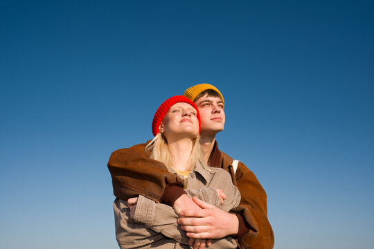 Couple Embraces Under Clear Blue Sky 