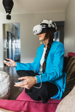 Female player sitting on a couch and enjoying virtual reality