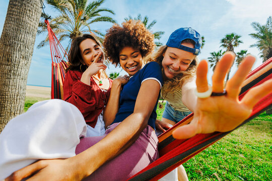Diverse friends enjoying summer vacation in hammock
