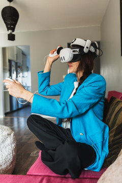 Female player sitting on a couch and enjoying virtual reality