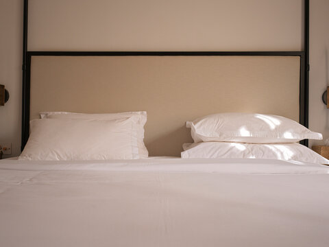 Clean Bed With White Pillows in a Simple Room Setting