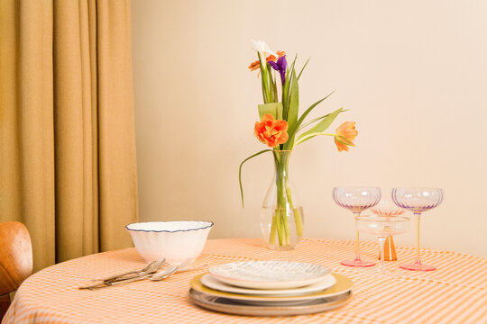 Dinner table set with flowers and dishes for gathering 