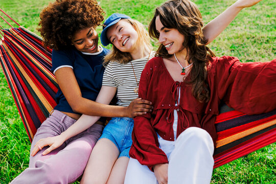 Diverse friends relaxing together in striped hammock