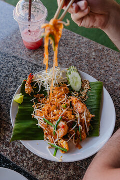Enjoying pad thai with chopsticks at a restaurant 
