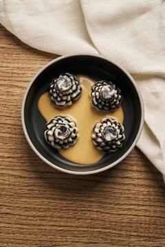 Striped khinkali dumplings with sauce in ceramic bowl