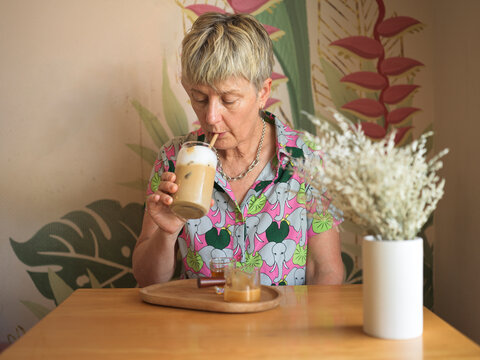 Woman Drinks Iced Coffee in Cafe During Daytime