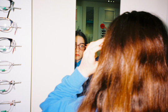 Girl checking glasses in mirror