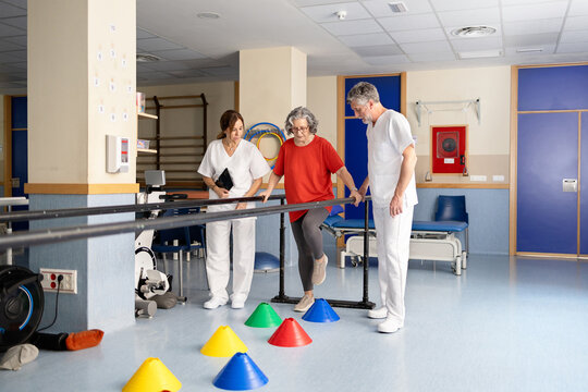 Geriatric patient doing balance exercise with physiotherapists