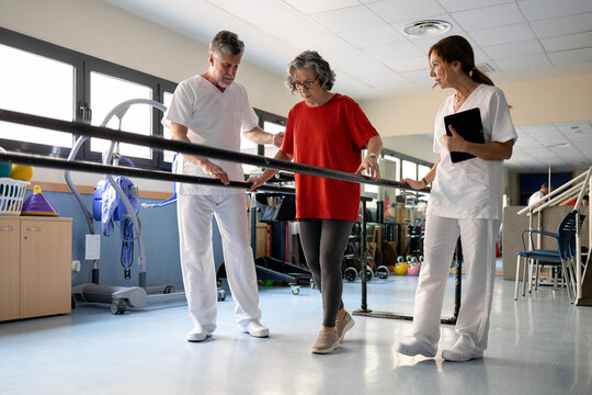 Physiotherapist assisting senior woman during walking rehabilitation