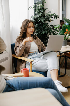 Woman Works on Laptop in a Cozy Indoor Space
