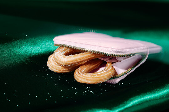 churros inside a pink purse on dark green satin, prism filter
