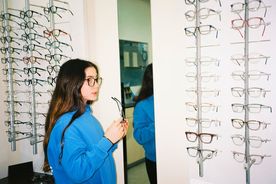 Girl trying glasses in optical store