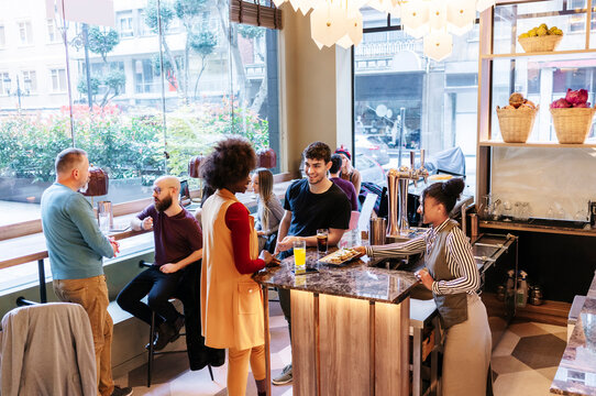 Diverse people socializing and enjoying drinks at a modern bar