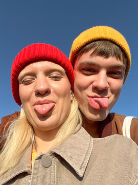 Friends Making Silly Faces Outdoors Under a Clear Blue Sky UGC