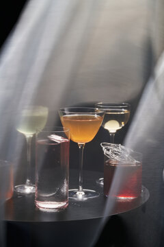 Colorful cocktails in glasses under translucent fabric